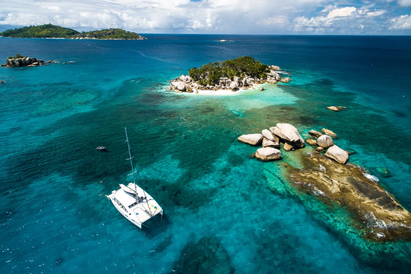 A catamaran anchored by granite rocks