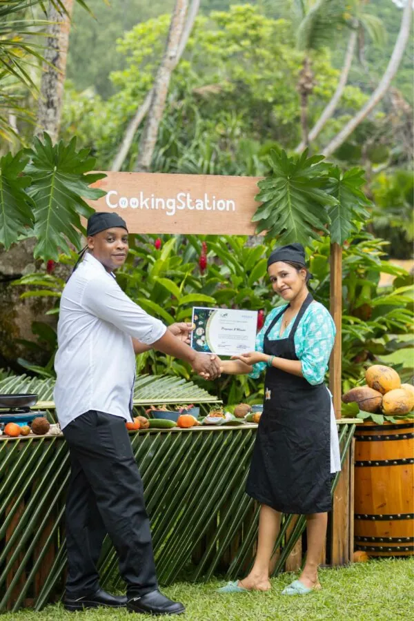 A guest receiving her cooking class certificate