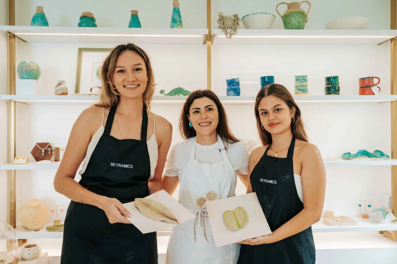 Guests showing their finished pieces in the boutique