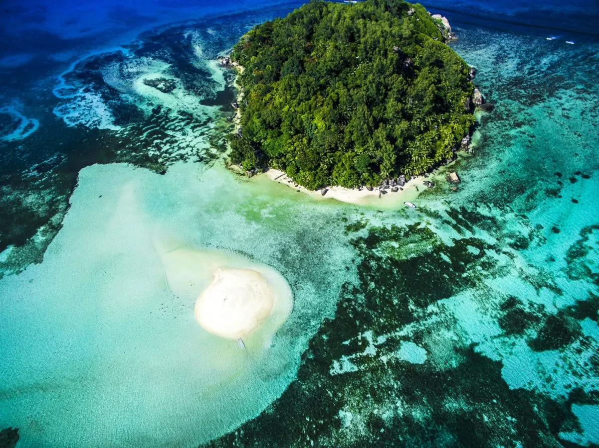 Aerial view of an island ringed by reef in Ste Anne Marine Park