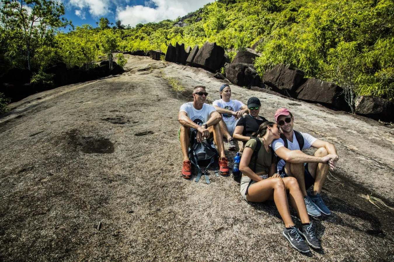 Hikers resting on a granite slab along the trail