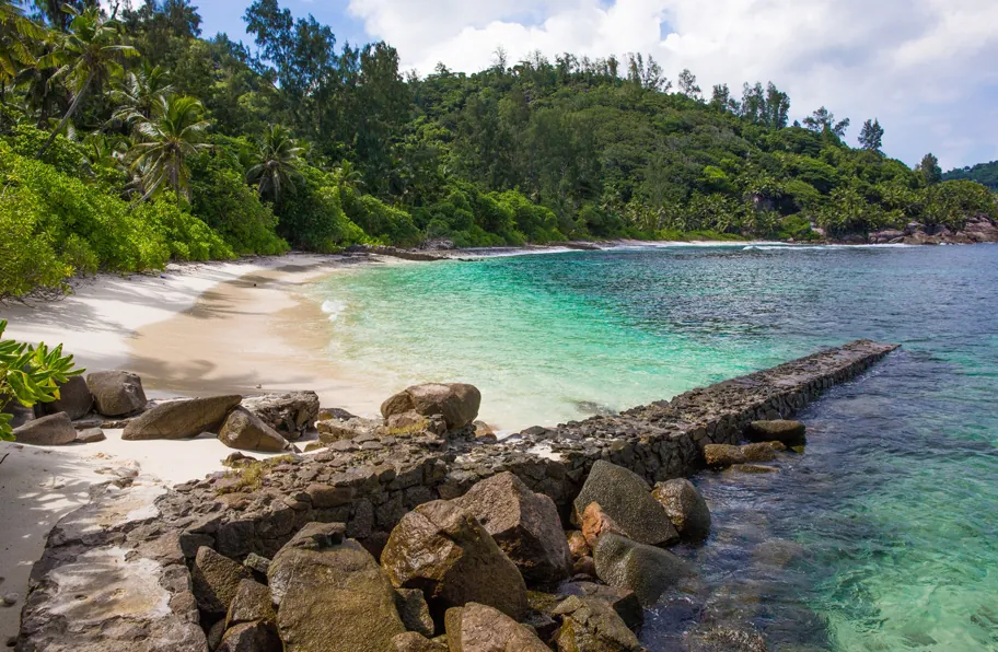 A quiet beach with a rocky breakwater