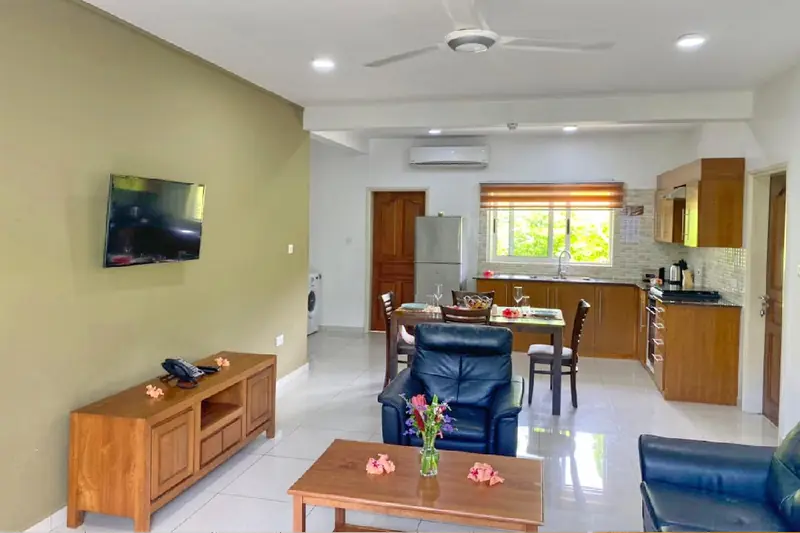Living room with armchairs, dining table and kitchen