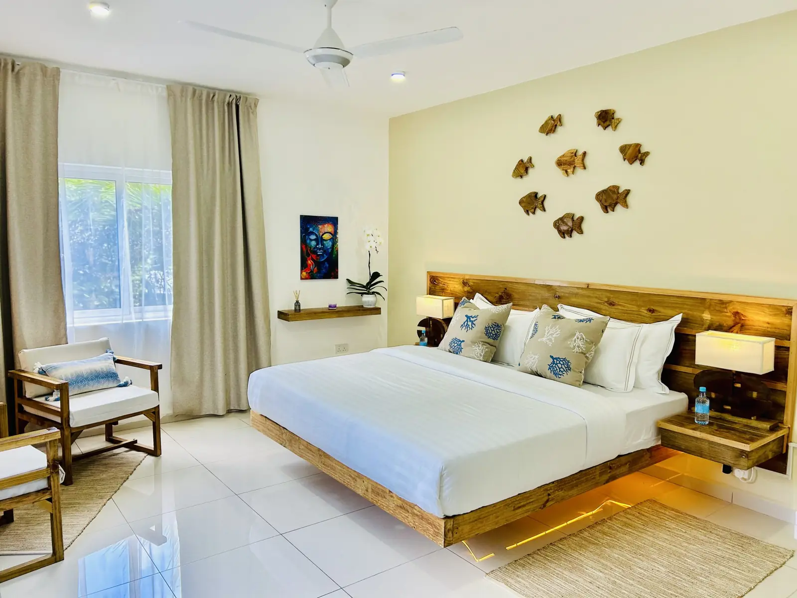 The king bed and reading chairs by the window